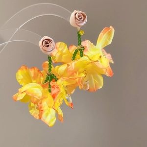 Detailed macro of fabric floral tassel earrings with beads and water drop pendant