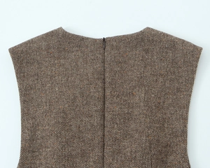 Dettaglio della cerniera invisibile su abito in lana tweed marrone con trama tessuta