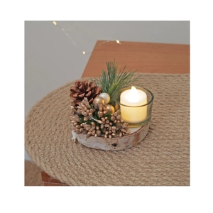 Close-up of a Christmas candle holder with pine cones and golden berries on wood base