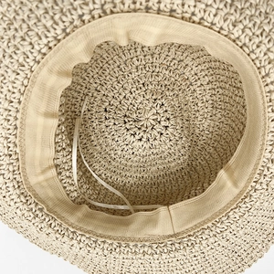 Interior detail of a foldable straw sun hat with adjustable sweatband and woven texture