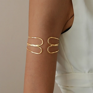 Detail of minimalist gold multi-layer geometric upper arm cuff on a female model