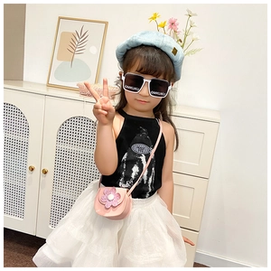 Close-up of pink flower shaped crossbody bag on a child model with black sunglasses