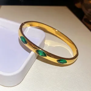 Sparkling zircon heart oval bangle in gold finish with marquise green gemstones