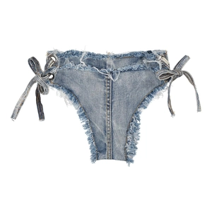 Dettaglio degli shorts in denim azzurro con allacciatura laterale e bordi con frange