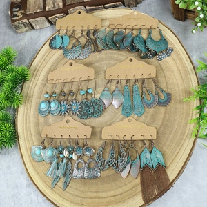 Detail of 6 pairs vintage bohemian earrings set with turquoise and tassel on wood background