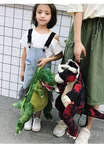 Detail of plush dinosaur backpacks showing green T-Rex and red Triceratops with soft fabric
