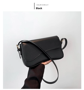 Detail of black matte leather shoulder bag with magnetic flap and adjustable strap
