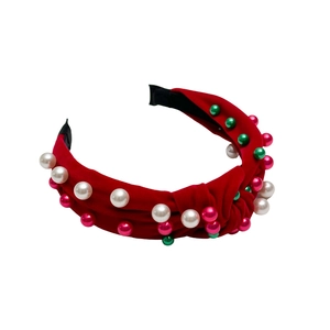 Serre-tête en velours rouge orné de perles blanches, roses et vertes sur fond blanc