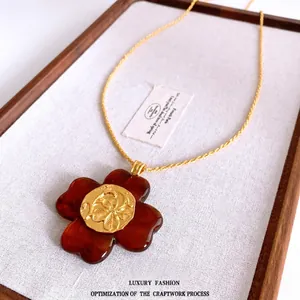 Vintage resin flower pendant necklace with amber texture and gold embossed floral center