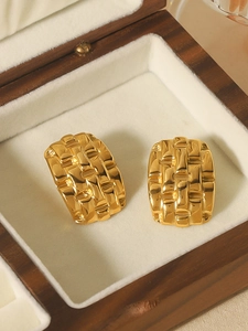 Detail of gold woven texture earrings displayed in a luxury wooden jewelry gift box