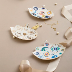 Dettaglio di vassoi per gioielli in ceramica a forma di mano di Hamsa con bordo oro