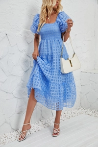 Close-up of light blue plaid maxi dress with puff sleeves and flowing tiered skirt detail