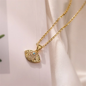 Détail macro du pendentif main de Hamsa doré avec pierre bleue et zircons étincelants sertis