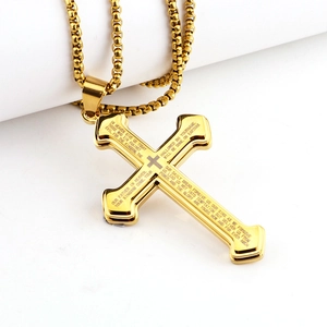 Detailed macro view of gold-plated stainless steel cross necklace with engraved scriptures