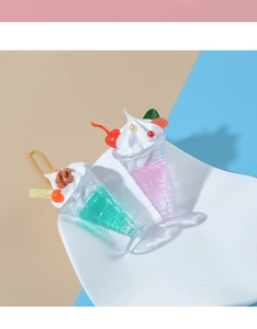 Close-up of realistic sundae charms with cream, cherry, and wafer on golden chains