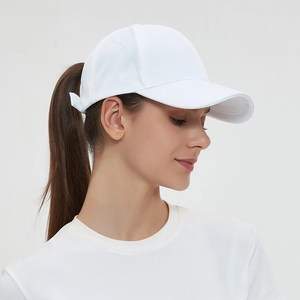 White baseball cap with ponytail opening, stylish side view on model in light grey studio