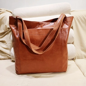 Vue détaillée du sac cabas vintage en cuir marron avec des anses en toile robustes