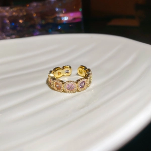 Detailed close-up of 14k gold plated ring with colorful zircon stones on white tray