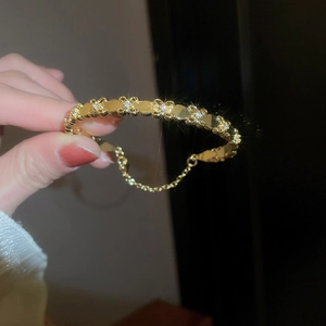 Detailed close-up of 18k gold plated iris cuff bracelet with sparkling zircon stones