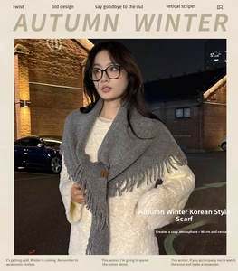 Close-up of grey knitted scarf with fringe edge details for winter warmth and style