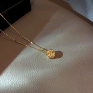 Close-up of gold titanium necklace featuring a Double Happiness pendant with pavé zircon