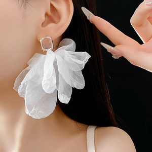 Nahaufnahme weißer Blumenohrring aus Netzstoff mit klarem Zirkonia am Modell