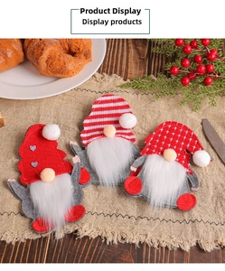 Three festive felt Christmas gnomes cutlery holders placed on a rustic burlap tablecloth