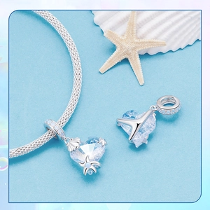 Macro shot of S925 sterling silver starfish and heart charms on a blue mesh bracelet