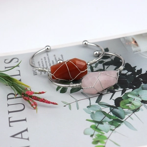 Detailed view of silver wire wrapped natural crystal bracelets on an open magazine