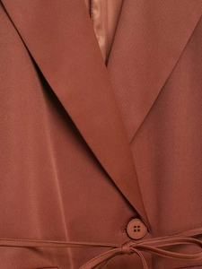 Detailed close-up of brown blazer notch lapels with woven texture and waist belt tie