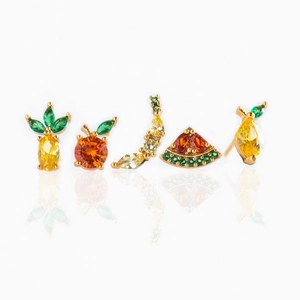 Detail of fruit-themed ear studs set with colorful cubic zirconia and gold metal
