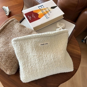 Detail of wool fabric cosmetic bag with cotton tag and lace flower zipper pendant