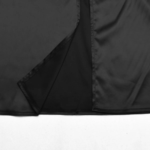 Detailed close-up showing the smooth black fabric texture and side slit of the evening dress