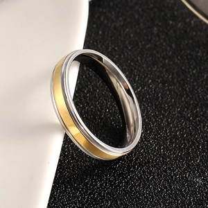 Detailed view of bicolor silver and gold stainless steel ring on black background