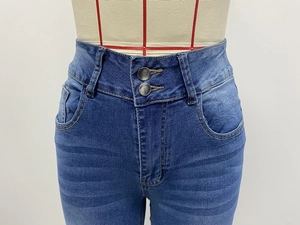 Close-up of high-waisted blue denim jeans featuring unique double metal button closure