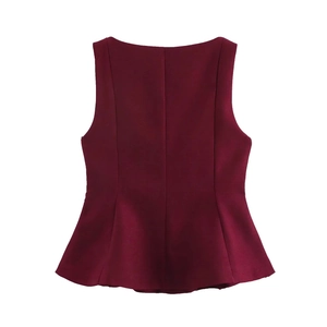 Detail view of burgundy sleeveless top featuring slim-fit waist and asymmetric hem design