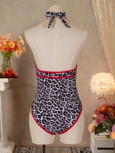 Sexy leopard print halter neck one-piece swimsuit with red piping on mannequin