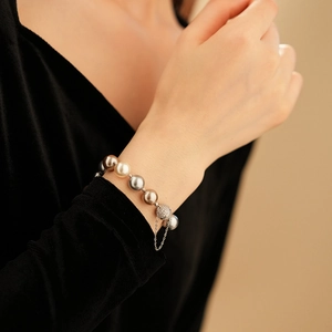 Close-up of multicolored pearl bracelet with crystal-studded clasp and security chain