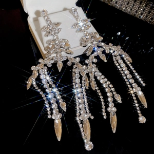 Close-up of sparkling geometric leaf tassel earrings with crystal fringe details
