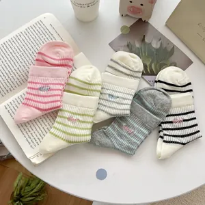 Close-up of five pairs of striped cotton socks with delicate miao letter embroidery