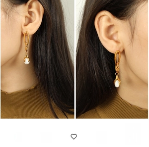 Close-up of 18K gold-plated irregular chain earrings with drop pearls on a model