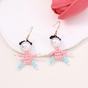 Detail of handmade beaded doll earrings featuring pink and blue beads on a textured base