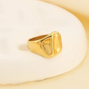 Macro shot of gold-plated lava ring featuring irregular fluid design and polished finish