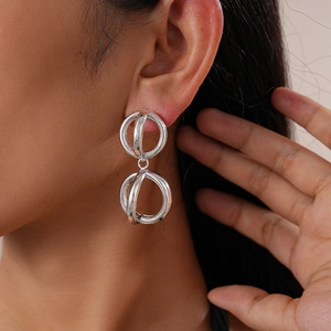 Close-up of model wearing glossy geometric hollow silver needle hoop earrings