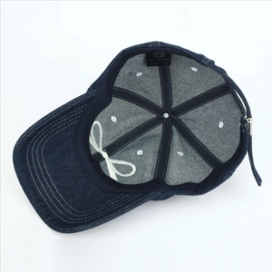 Internal structure of blue denim baseball cap with six-panel stitching and white bow tie