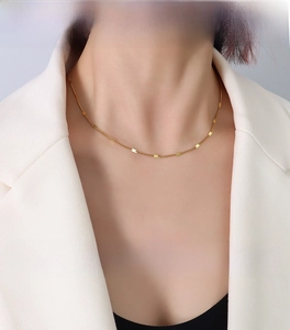 Detail of 1.4mm gold titanium steel flat curb chain necklace on model neck