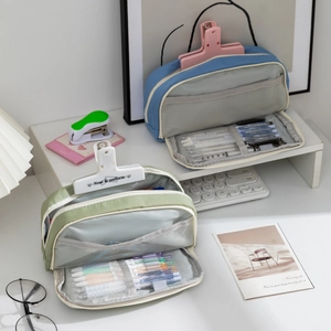 Detail of blue and green canvas pencil cases with dual-layer storage and mesh pockets