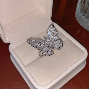 Vue macro d'une bague papillon argentée sertie de zircons brillants sur présentoir