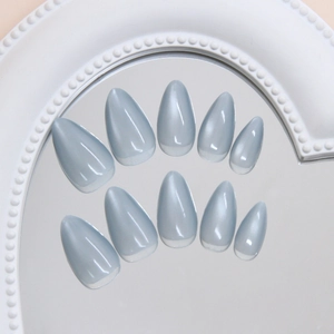 Elegant light blue pearl almond press-on nails displayed on a mirror for a fresh look