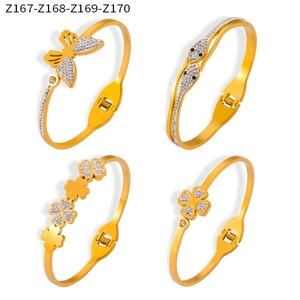 Detailed view of four gold-plated bangles with pavé diamond butterfly and clover designs